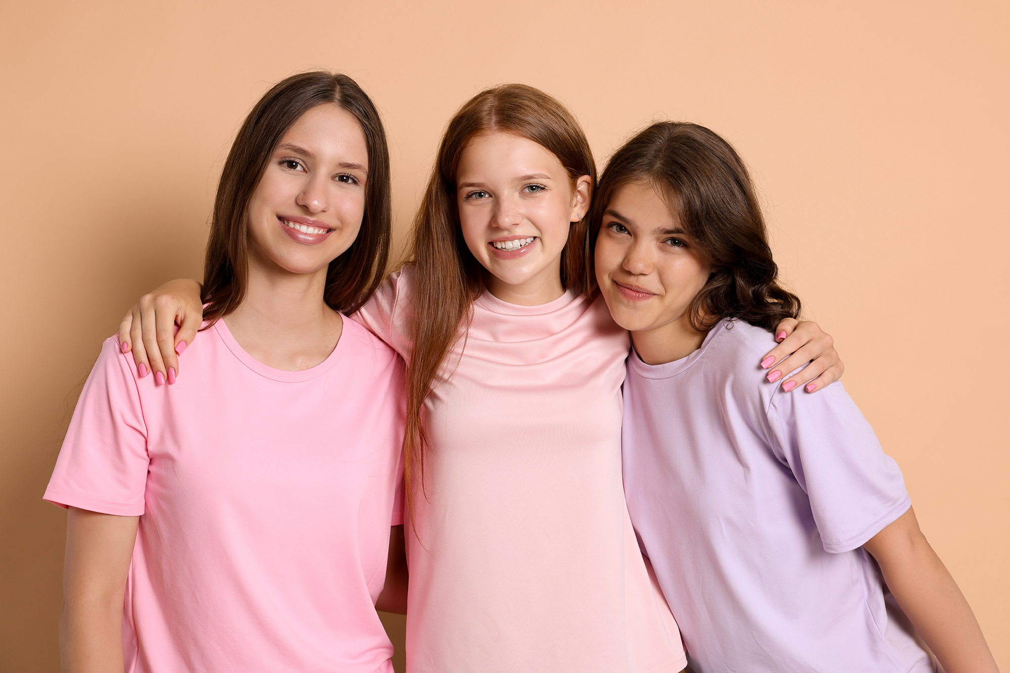 Portrait of happy friends on beige background